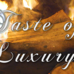 The words "Taste of Luxury" are written in a fancy white script and are superimposed over a photo of burning logs.